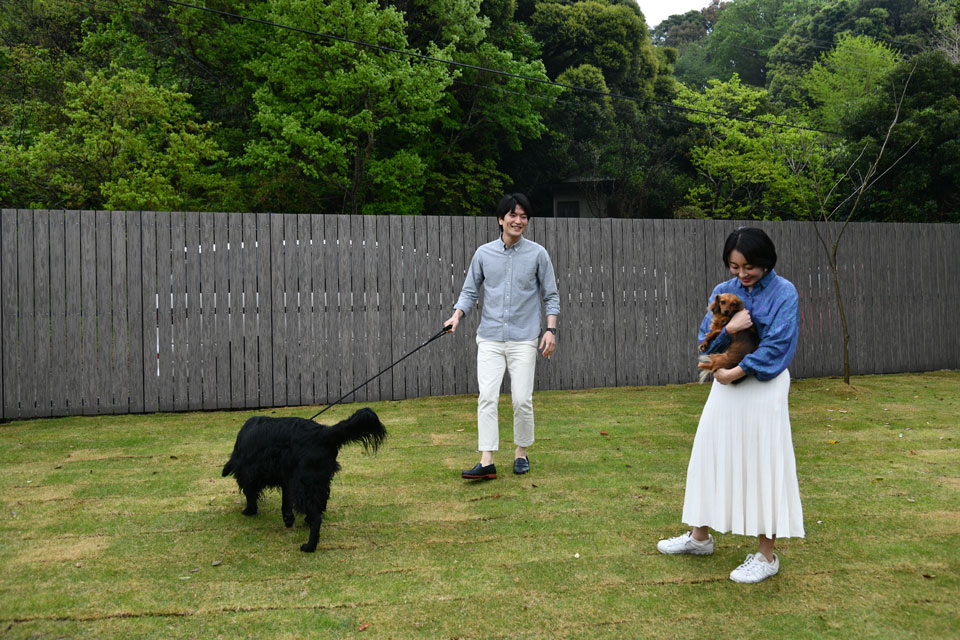 BON-MAL TREEの芝生の庭で愛犬と過ごす様子