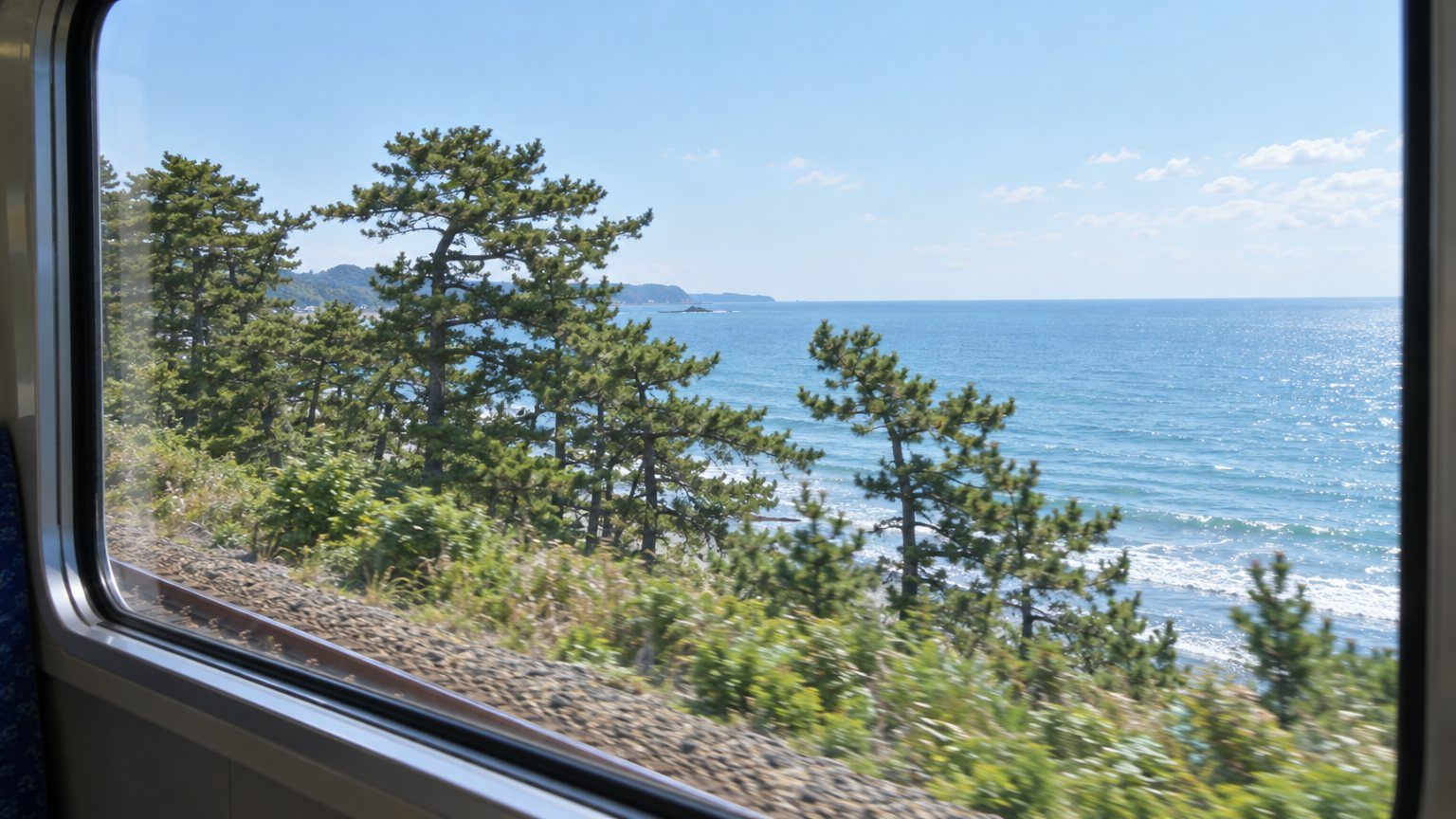海沿いを走る列車の車窓から見える海のイメージ